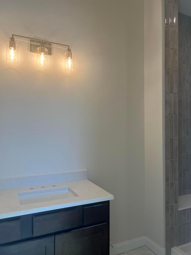 full bath featuring vanity and baseboards