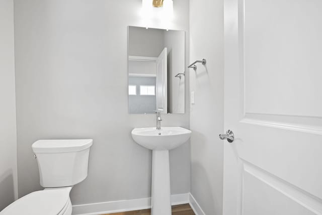 bathroom featuring wood-type flooring and toilet