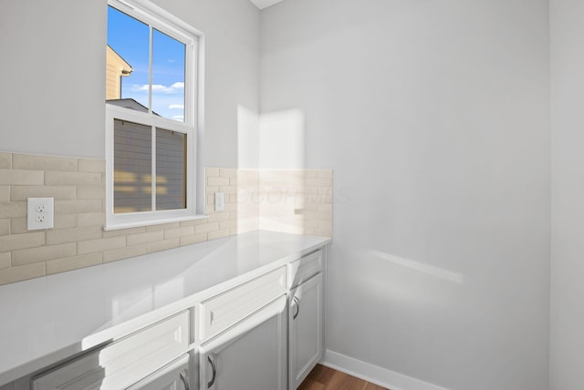 bathroom with wood-type flooring and decorative backsplash