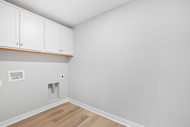 clothes washing area featuring light hardwood / wood-style flooring, hookup for an electric dryer, hookup for a washing machine, and cabinets