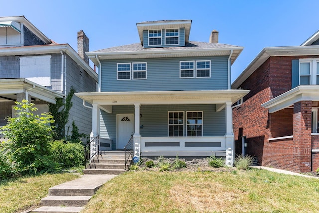 view of front facade featuring covered porch and a front lawn