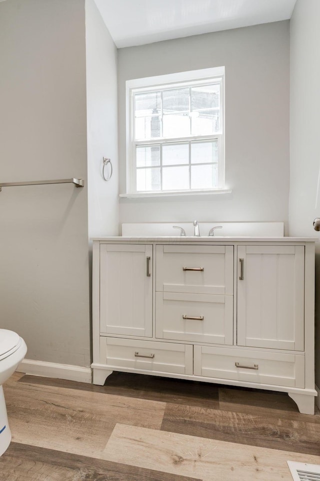 bathroom featuring hardwood / wood-style flooring, vanity, and toilet