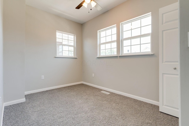 spare room featuring carpet flooring, ceiling fan, and a healthy amount of sunlight