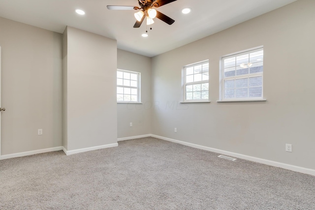 carpeted spare room featuring ceiling fan