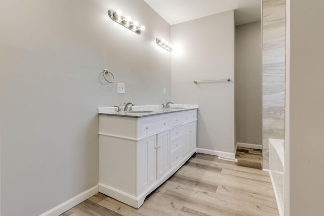 bathroom with hardwood / wood-style floors, vanity, and a bathtub