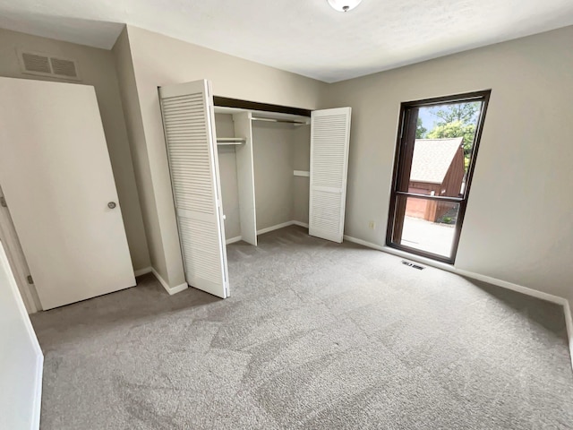 unfurnished bedroom with a closet and light colored carpet