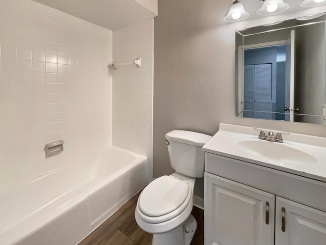 full bathroom with vanity, hardwood / wood-style floors, washtub / shower combination, and toilet