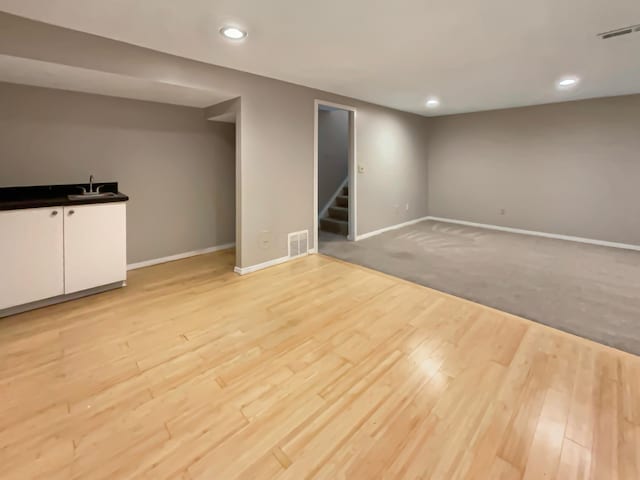 basement with light colored carpet and sink