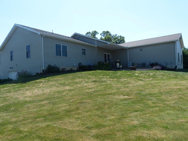 rear view of property featuring a lawn