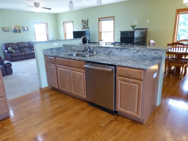 kitchen featuring dishwasher, stone counters, plenty of natural light, and sink