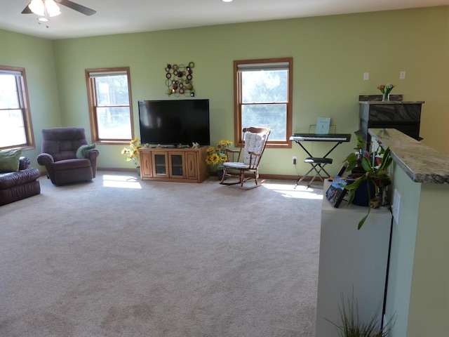 carpeted living room featuring ceiling fan and a wealth of natural light