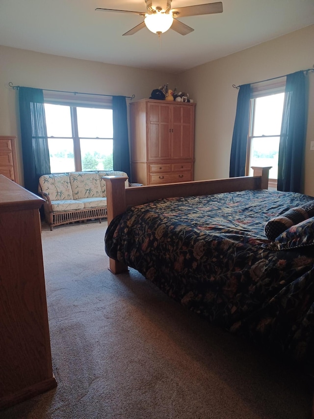 carpeted bedroom featuring multiple windows and ceiling fan