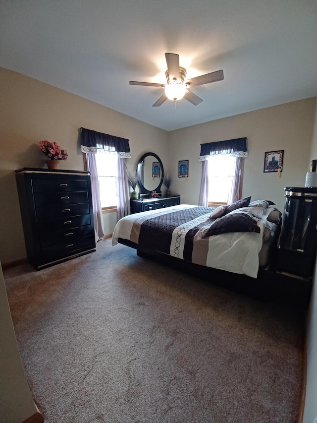 bedroom with dark carpet, multiple windows, and ceiling fan