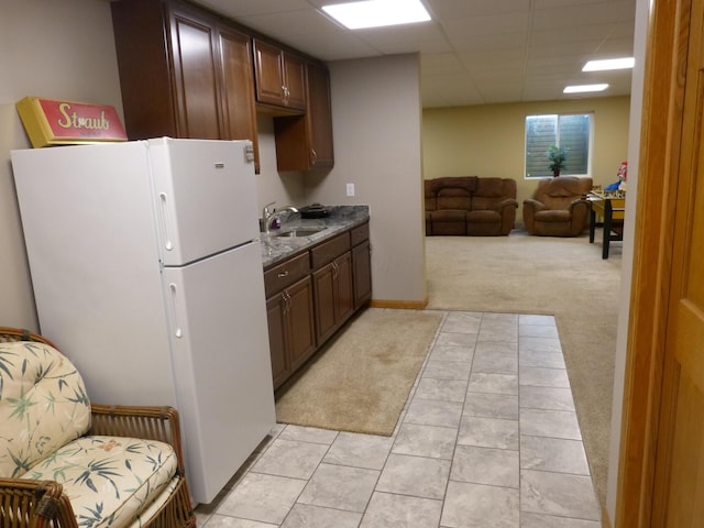 kitchen with light carpet, white refrigerator, a drop ceiling, and sink