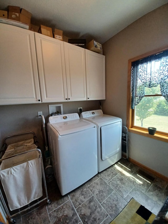 clothes washing area with cabinets and independent washer and dryer