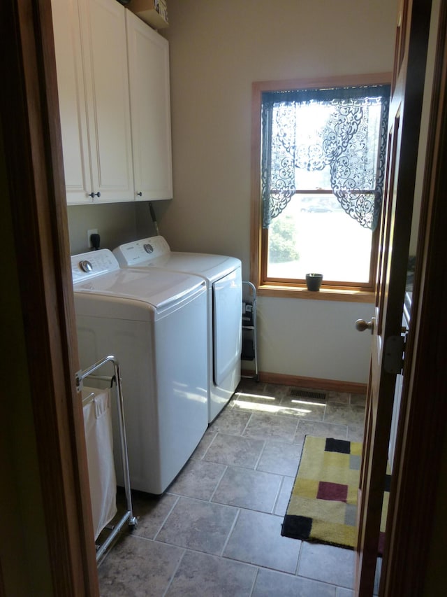 laundry area featuring washer and dryer and cabinets