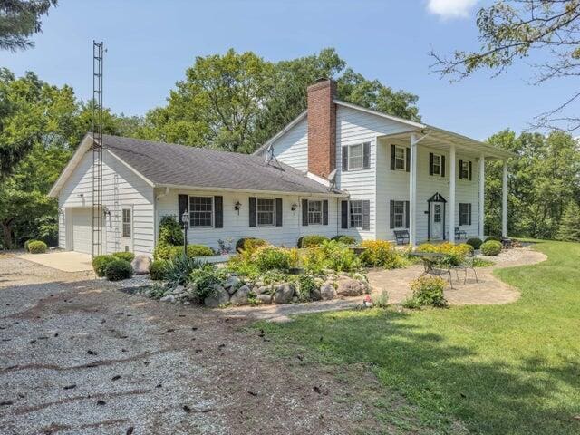 back of property with a yard and a garage