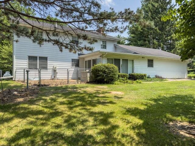 rear view of property with a lawn