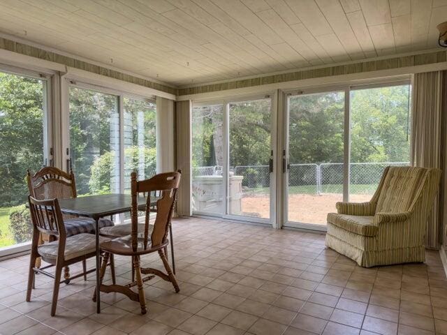 sunroom featuring a healthy amount of sunlight and wood ceiling