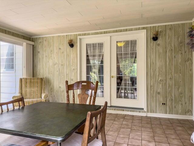 tiled dining area with wooden walls and french doors