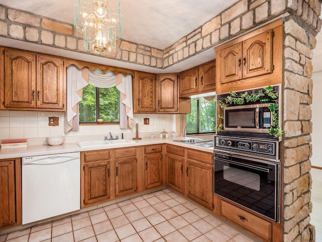 kitchen with appliances with stainless steel finishes, backsplash, and a healthy amount of sunlight