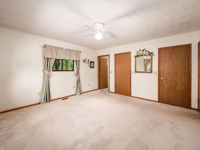 spare room with carpet flooring, ceiling fan, and a textured ceiling