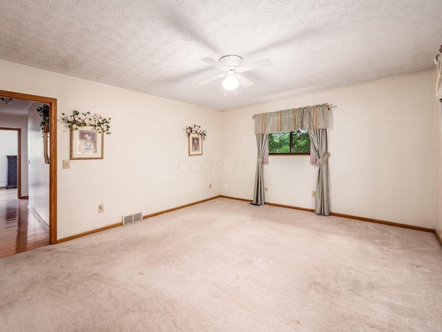 empty room with ceiling fan, carpet, and a textured ceiling