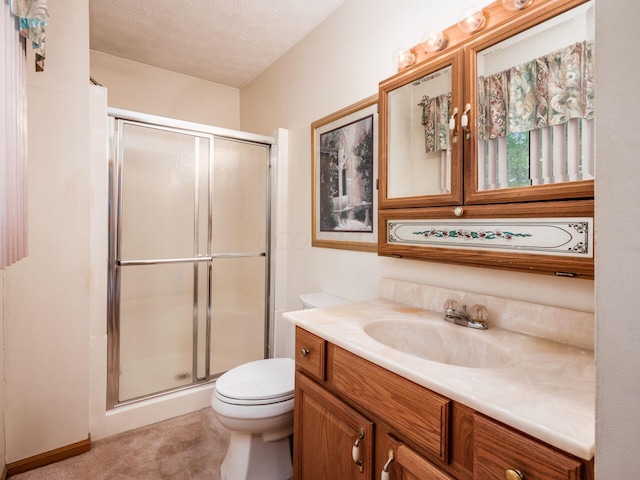 bathroom with vanity, a textured ceiling, toilet, and an enclosed shower