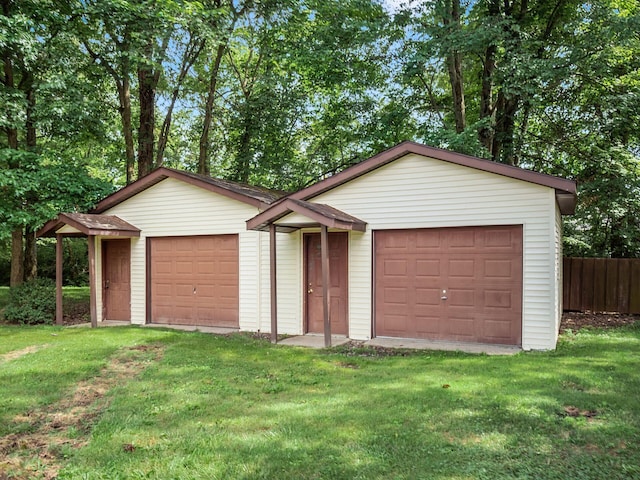 view of front of house with a front yard, a garage, and an outdoor structure