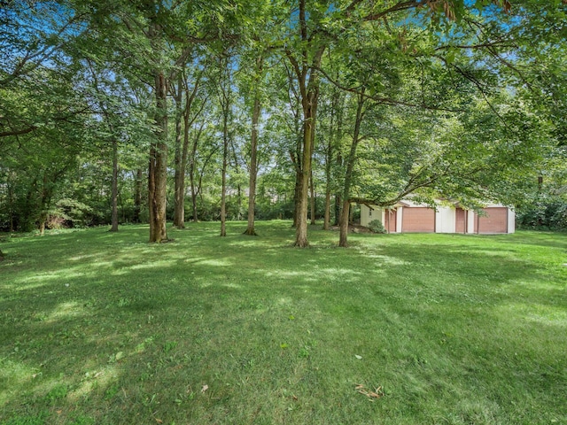 view of yard featuring a garage and an outbuilding