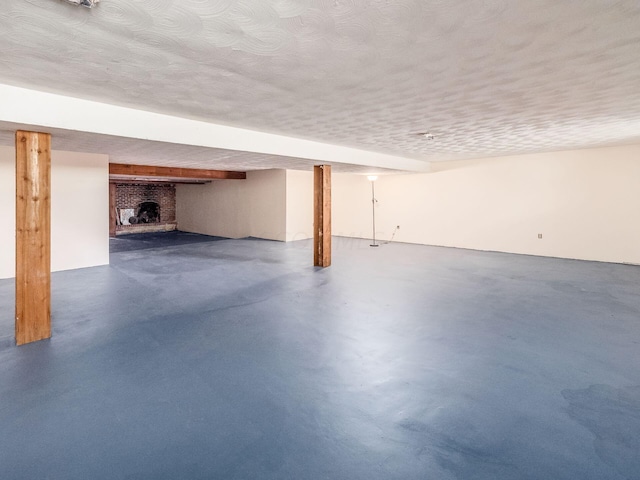 basement featuring a textured ceiling and a brick fireplace