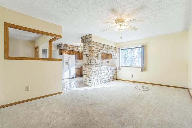 carpeted empty room featuring ceiling fan and a textured ceiling