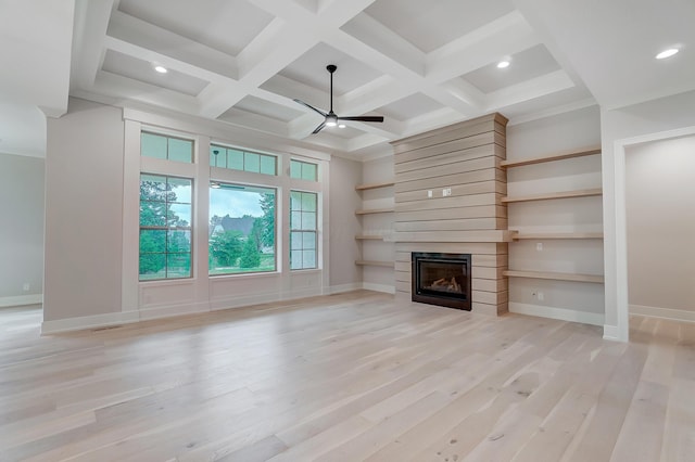 unfurnished living room featuring ceiling fan, a large fireplace, light hardwood / wood-style floors, and coffered ceiling