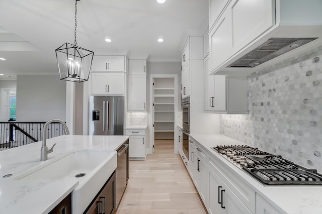 kitchen featuring backsplash, custom exhaust hood, stainless steel appliances, white cabinets, and hanging light fixtures