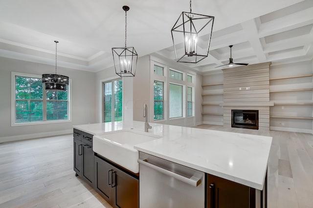 kitchen featuring a large fireplace, dishwasher, coffered ceiling, light hardwood / wood-style flooring, and decorative light fixtures