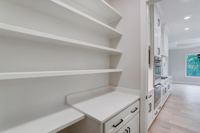 interior space with oven, white cabinetry, and light hardwood / wood-style flooring