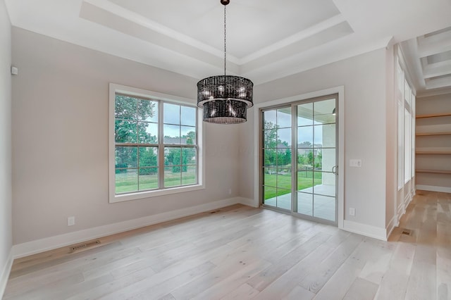 unfurnished dining area with a notable chandelier, light wood-type flooring, and a tray ceiling