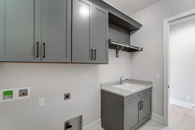 laundry room with hookup for an electric dryer, hookup for a washing machine, light wood-type flooring, cabinets, and sink