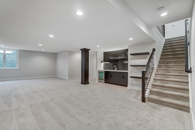 basement with light colored carpet, wine cooler, and wet bar