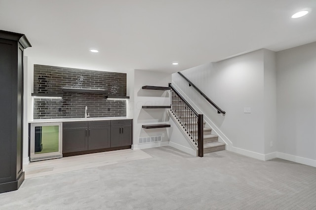 unfurnished living room featuring light colored carpet and indoor wet bar