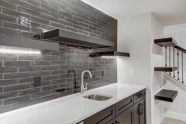 kitchen featuring dark brown cabinets, tasteful backsplash, and sink