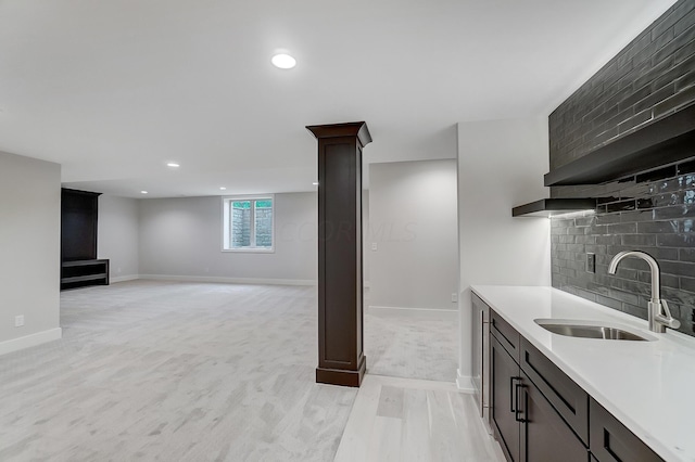 kitchen with dark brown cabinetry, light hardwood / wood-style flooring, and sink