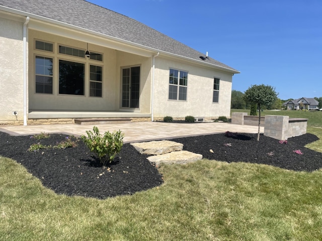 rear view of house featuring a lawn and a patio area