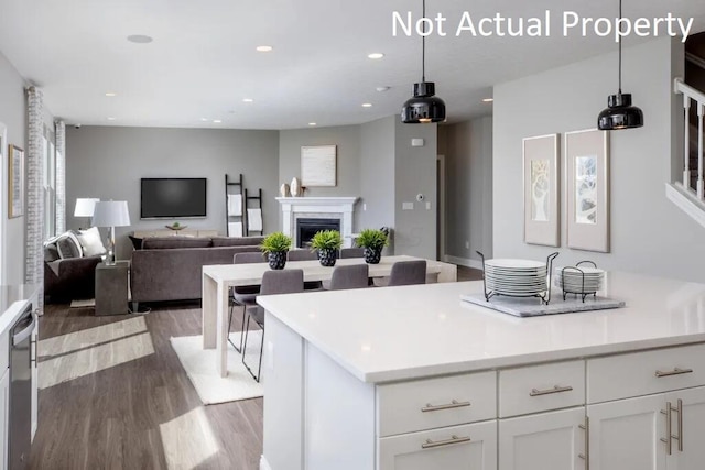 kitchen with white cabinetry, a kitchen island, pendant lighting, and light hardwood / wood-style floors