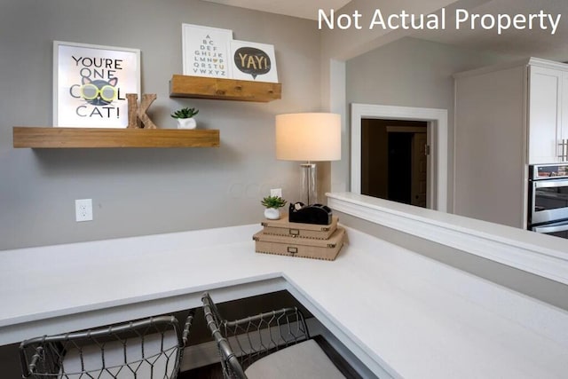 interior space with white cabinetry, stainless steel double oven, and vaulted ceiling