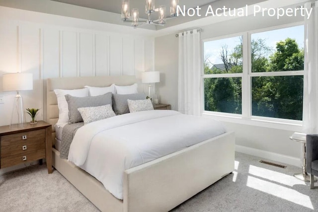 carpeted bedroom featuring a notable chandelier