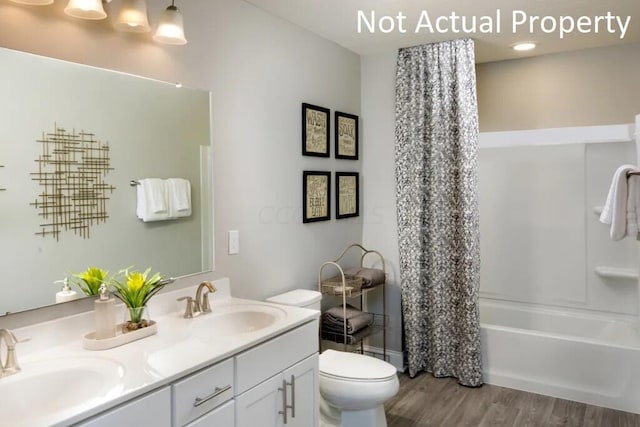 full bathroom with hardwood / wood-style flooring, vanity, toilet, and shower / bath combo with shower curtain