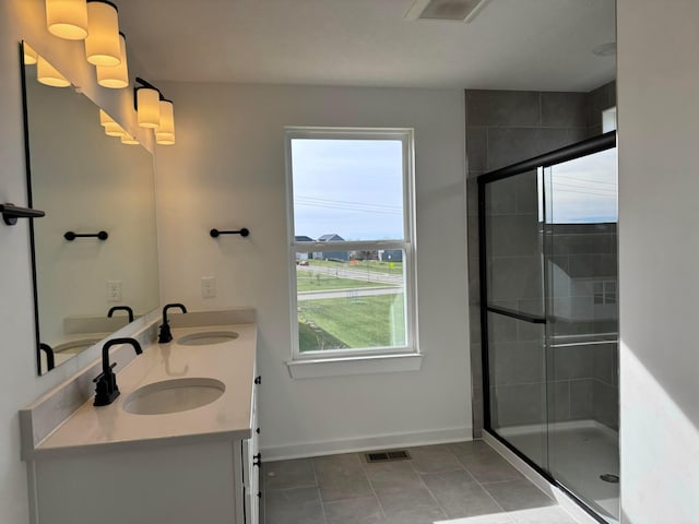 bathroom featuring tile patterned flooring, plenty of natural light, an enclosed shower, and vanity