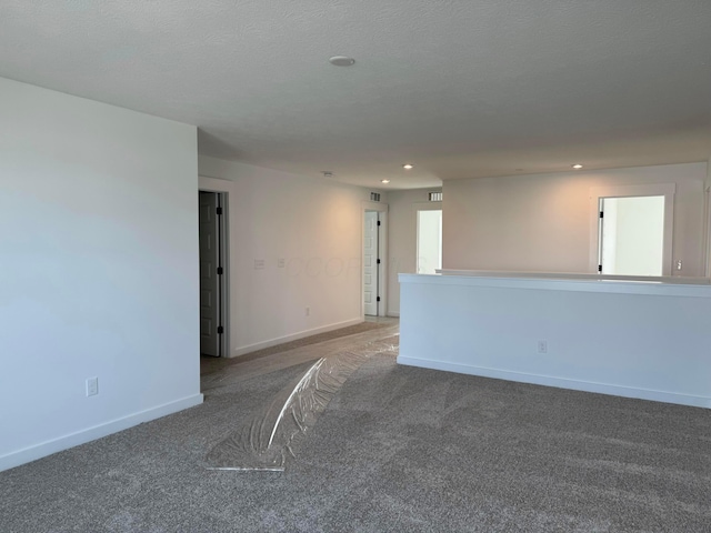 carpeted spare room with a textured ceiling