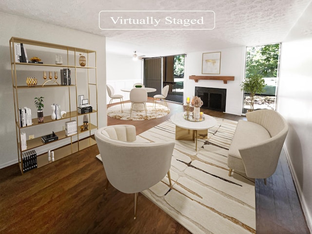 living room featuring ceiling fan, expansive windows, wood-type flooring, and a textured ceiling